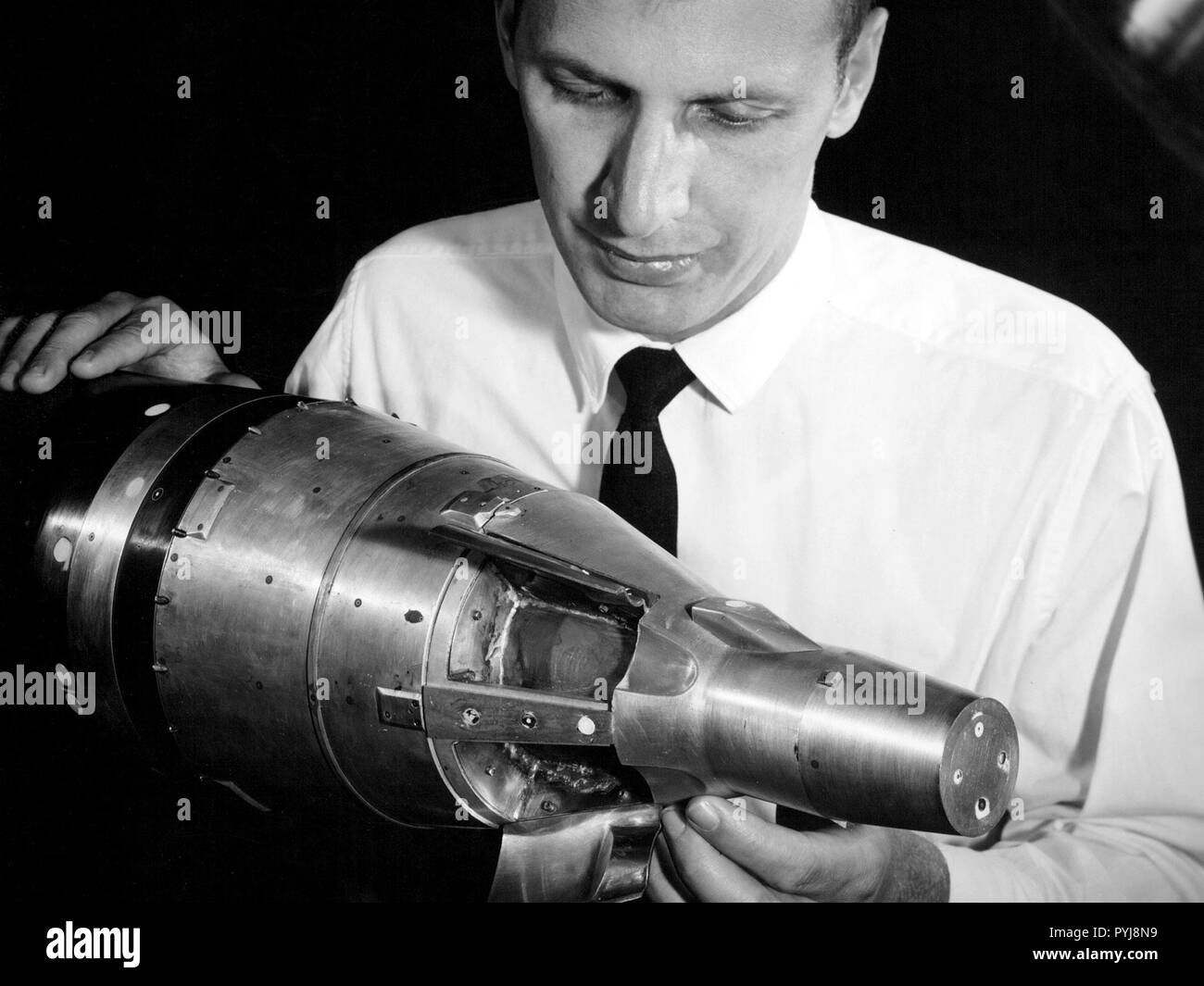 A researcher at the National Aeronautics and Space Administration (NASA) Lewis Research Center examines a small-scale model of the Gemini capsule in the 10- by 10-Foot Supersonic Wind Tunnel test section. Stock Photo