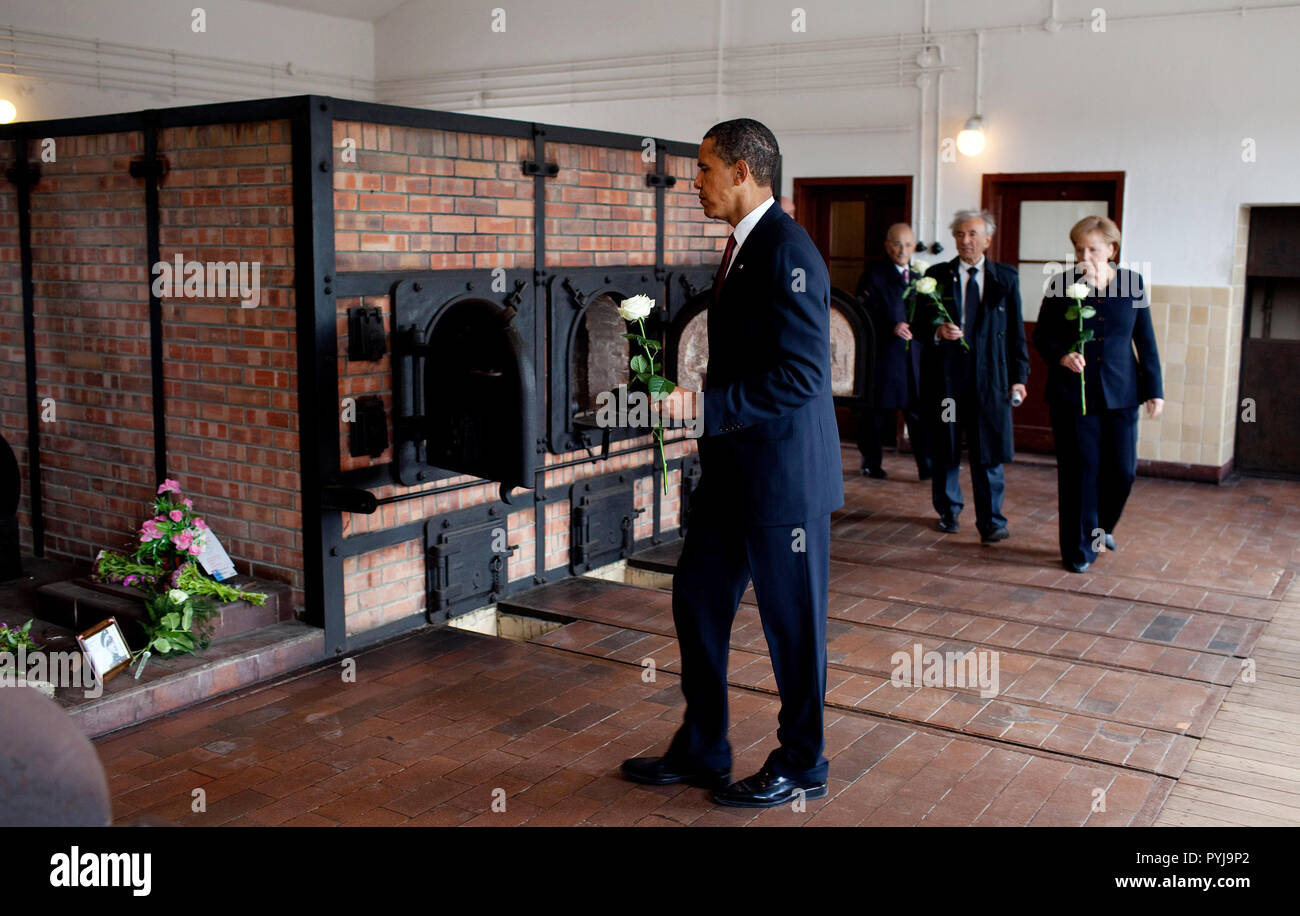 President Barack Obama places a flower at a memorial at Buchenwald Nazi concentration camp, June 5, 2009.  With the President are German chancellor Angela Merkel, and camp survivors Elie Wiesel and Bertrand Herz. Stock Photo
