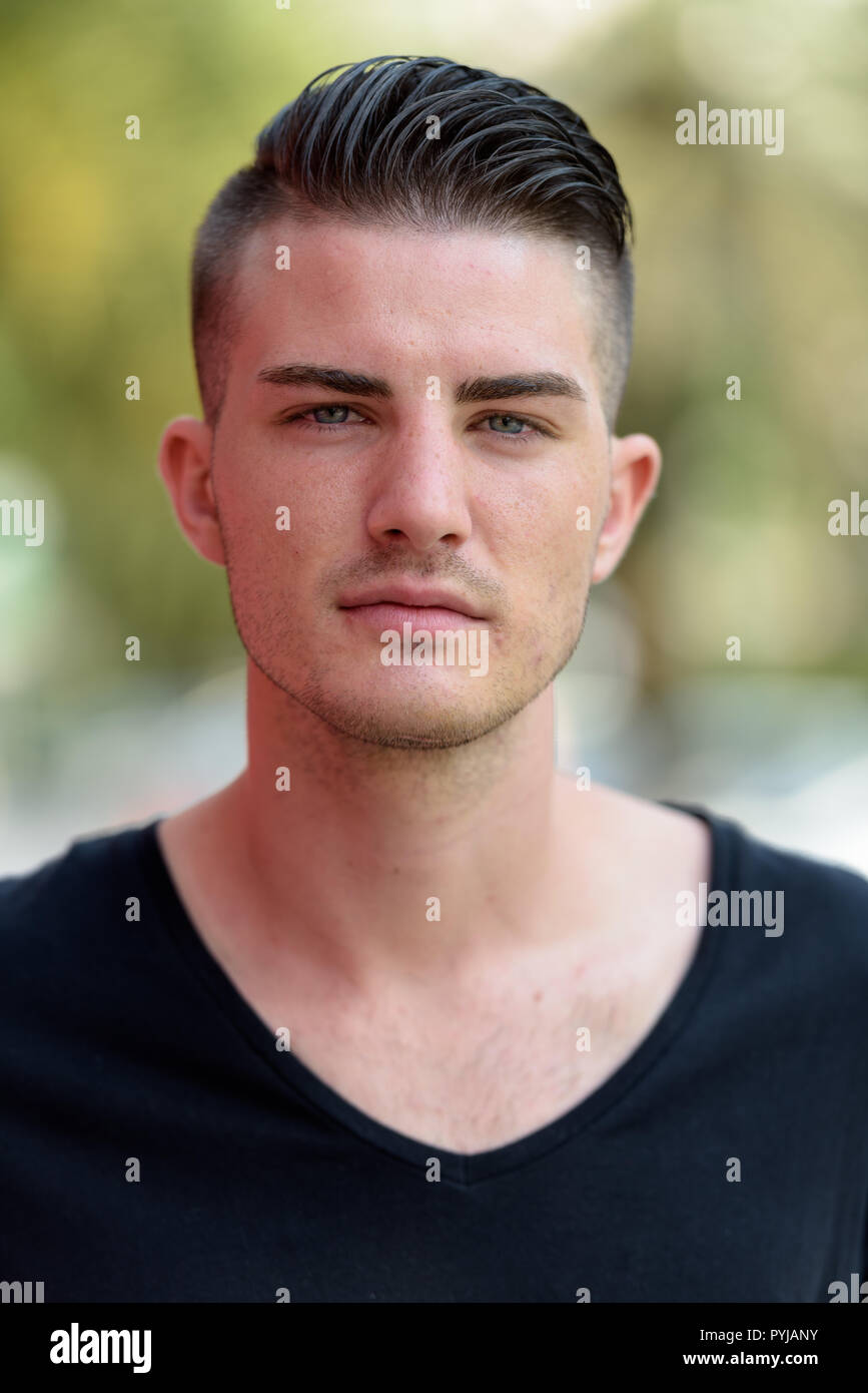 Face of young handsome man outdoors looking at camera Stock Photo