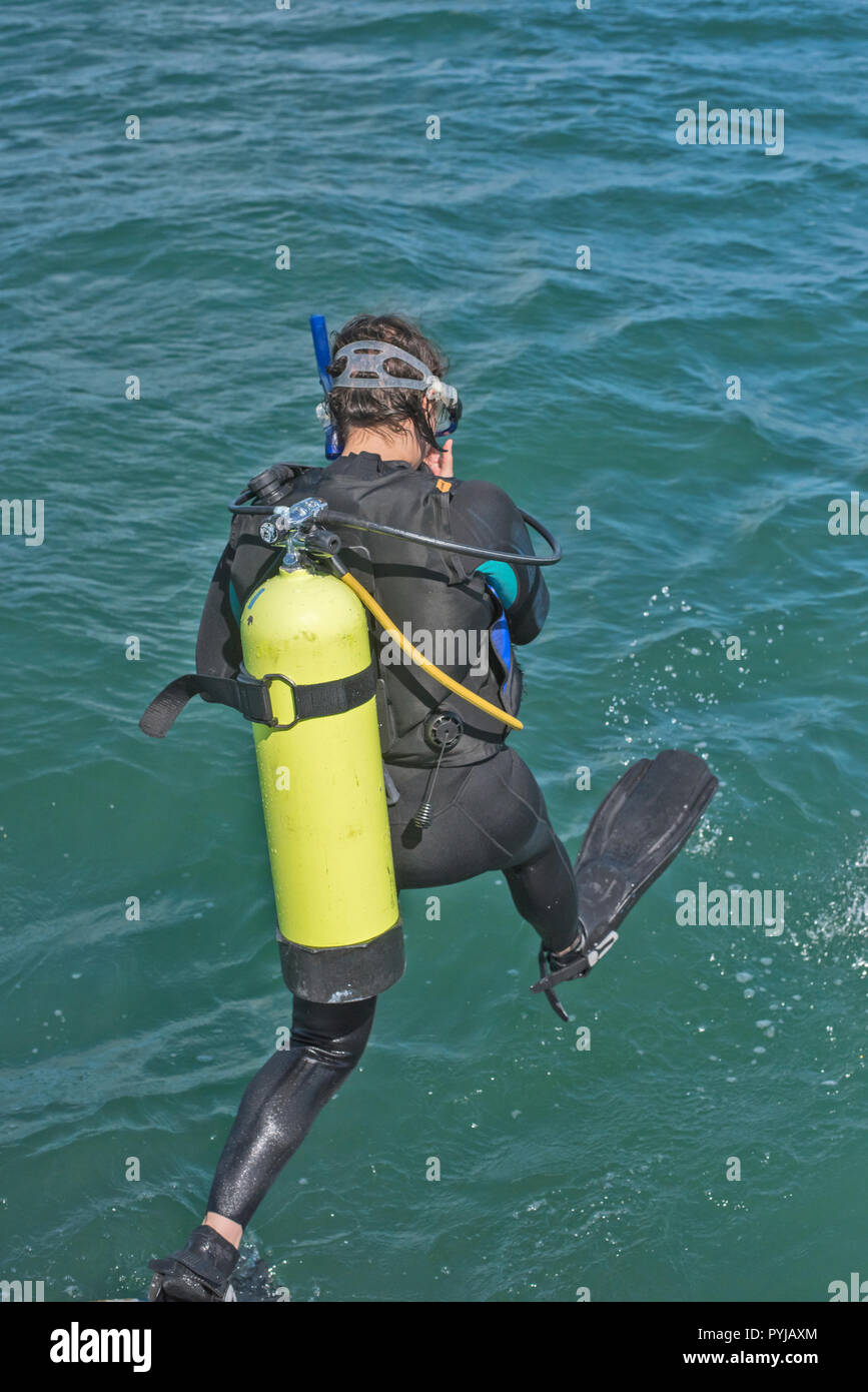 Scuba diver in wetsuit entering water from boat Stock Photo Alamy