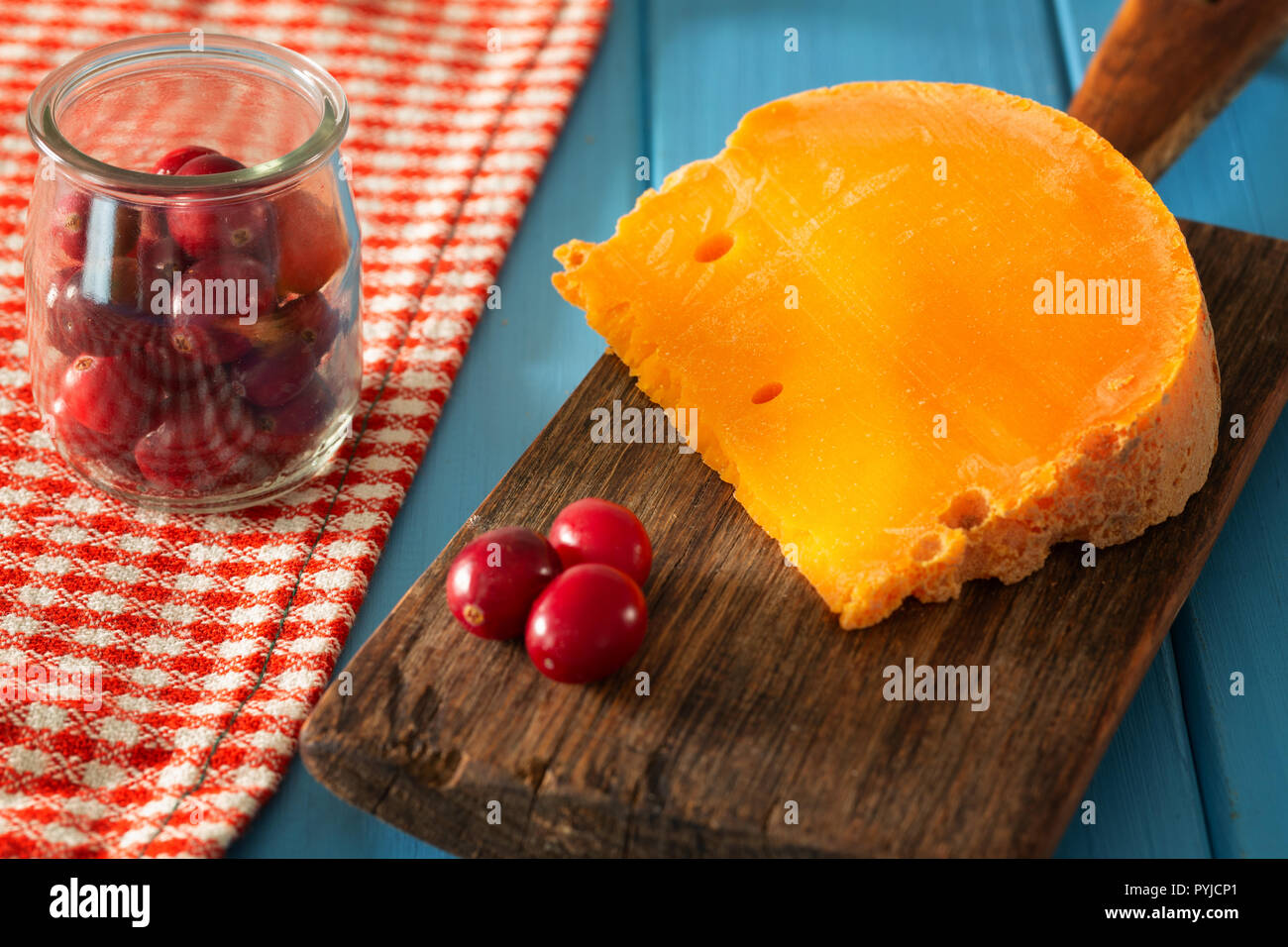 Mimolette,  type of cheese together with the addition of bread and fresh cranberries Stock Photo