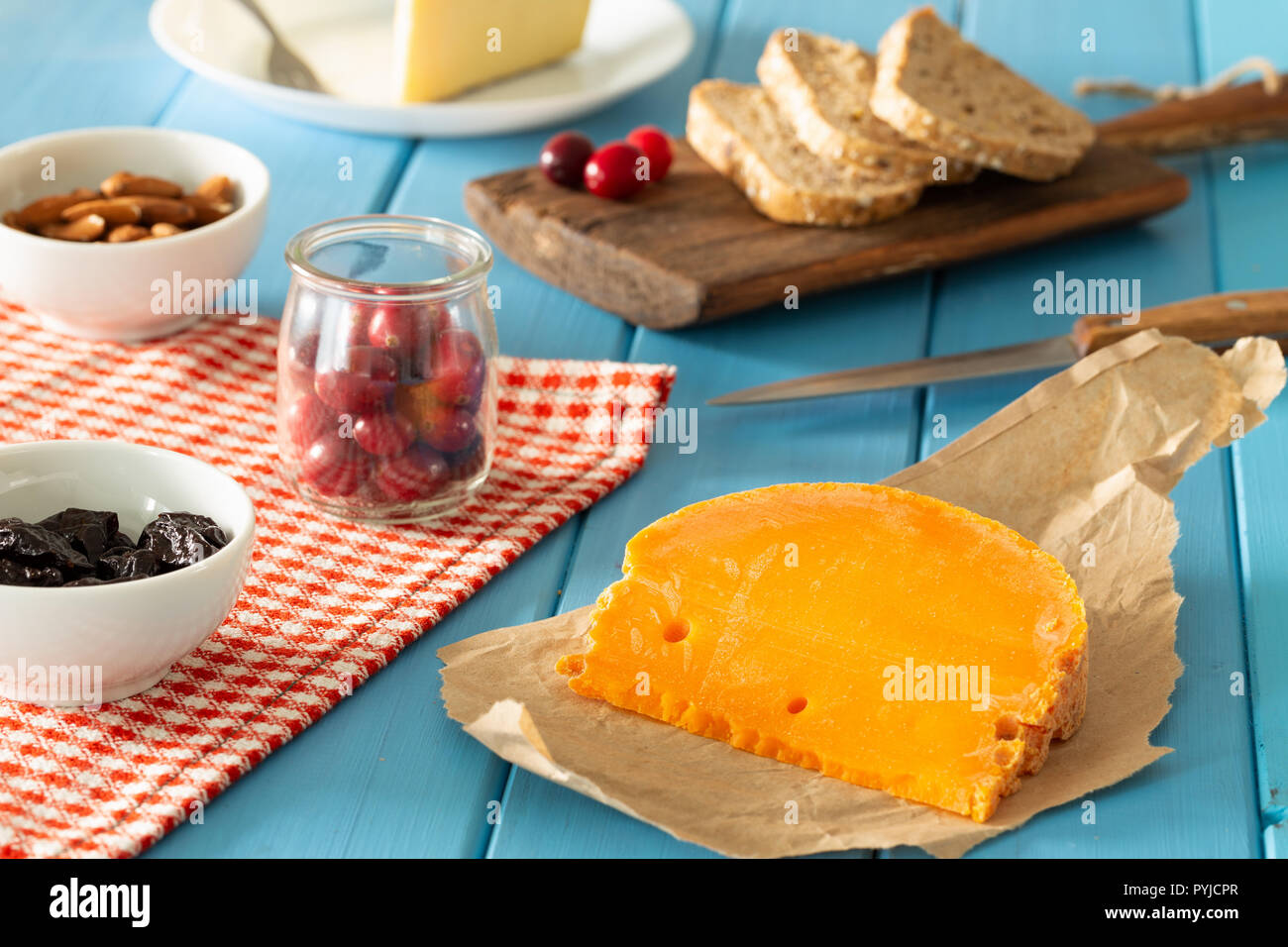 Mimolette,  type of cheese together with the addition of bread and fresh cranberries Stock Photo