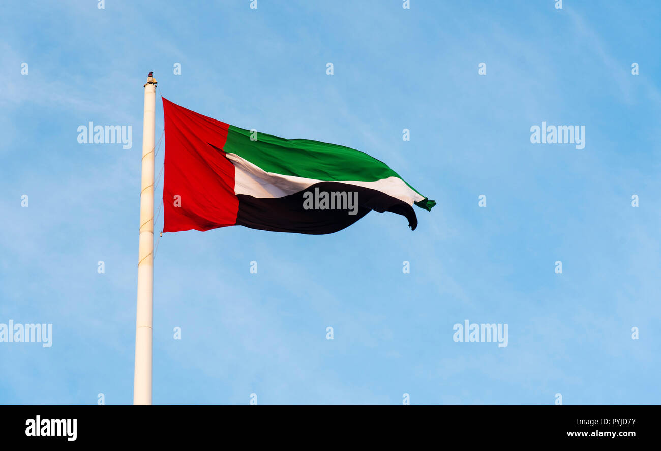 United Arab Emirates flag winding in the wind against blue sky Stock Photo