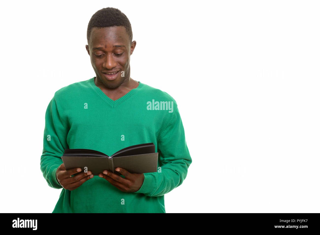 Young happy African man smiling and reading book  Stock Photo