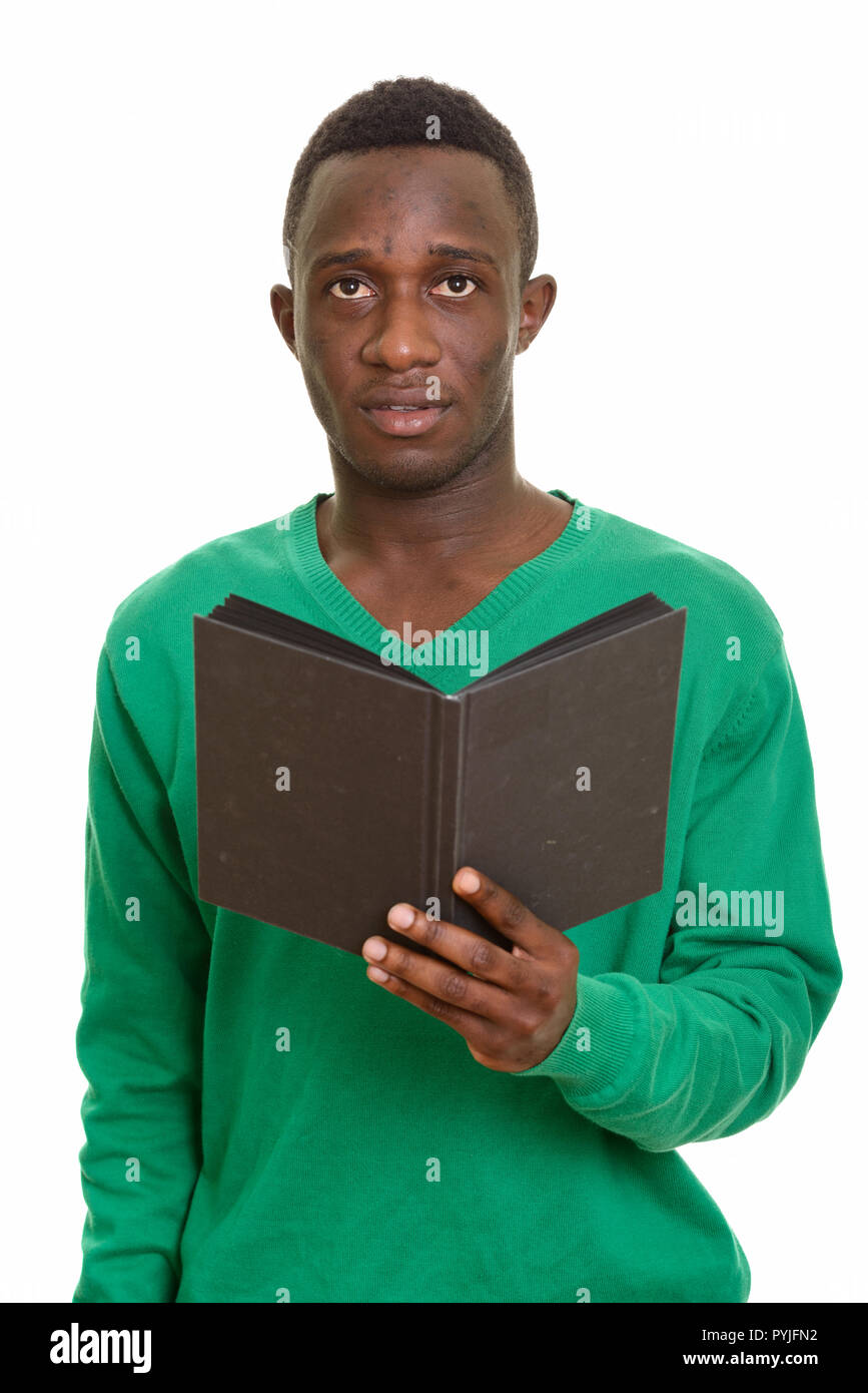 Young handsome African man holding book while thinking  Stock Photo