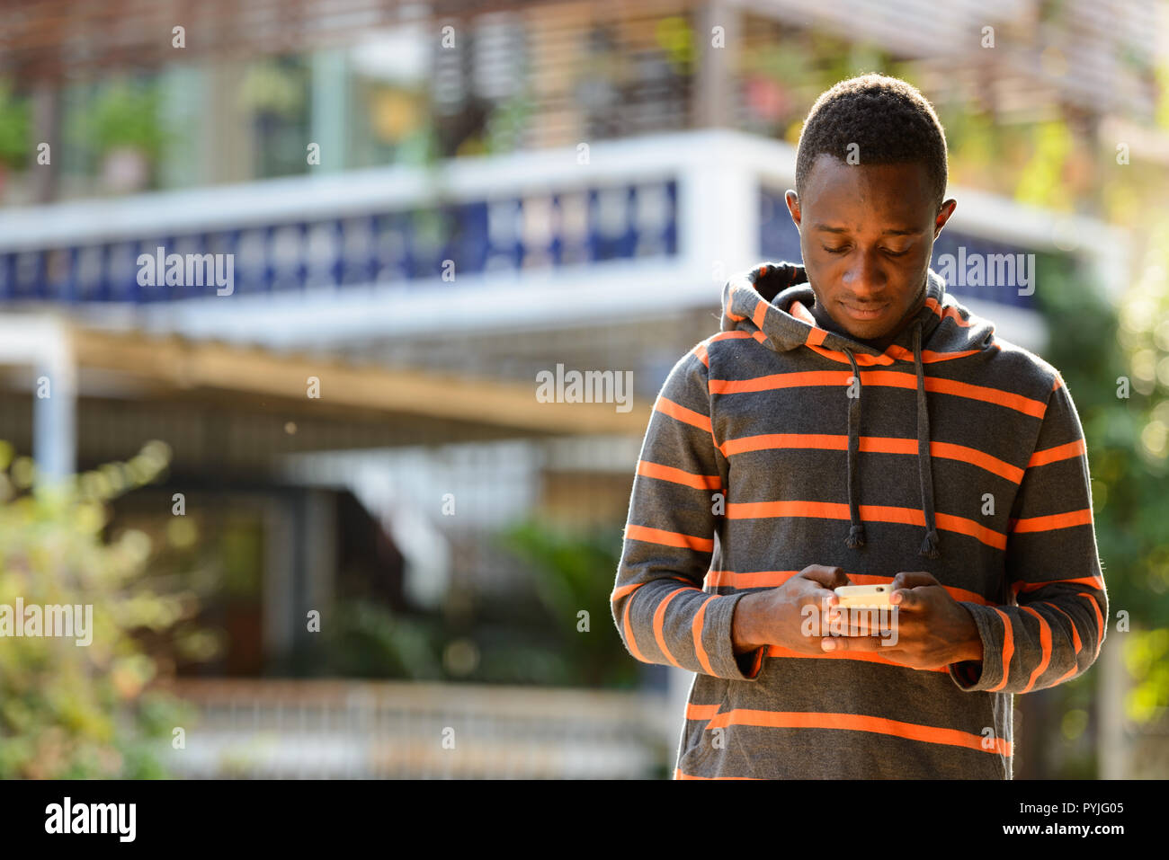 Young African man using mobile phone outdoors  Stock Photo