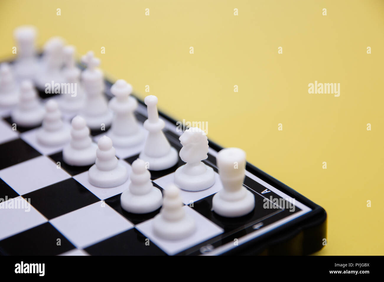 small pocket chess, plastic chess pieces placed on a chessboard on a