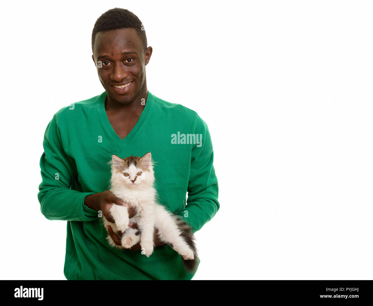 Young happy African man smiling and holding cute cat Stock Photo
