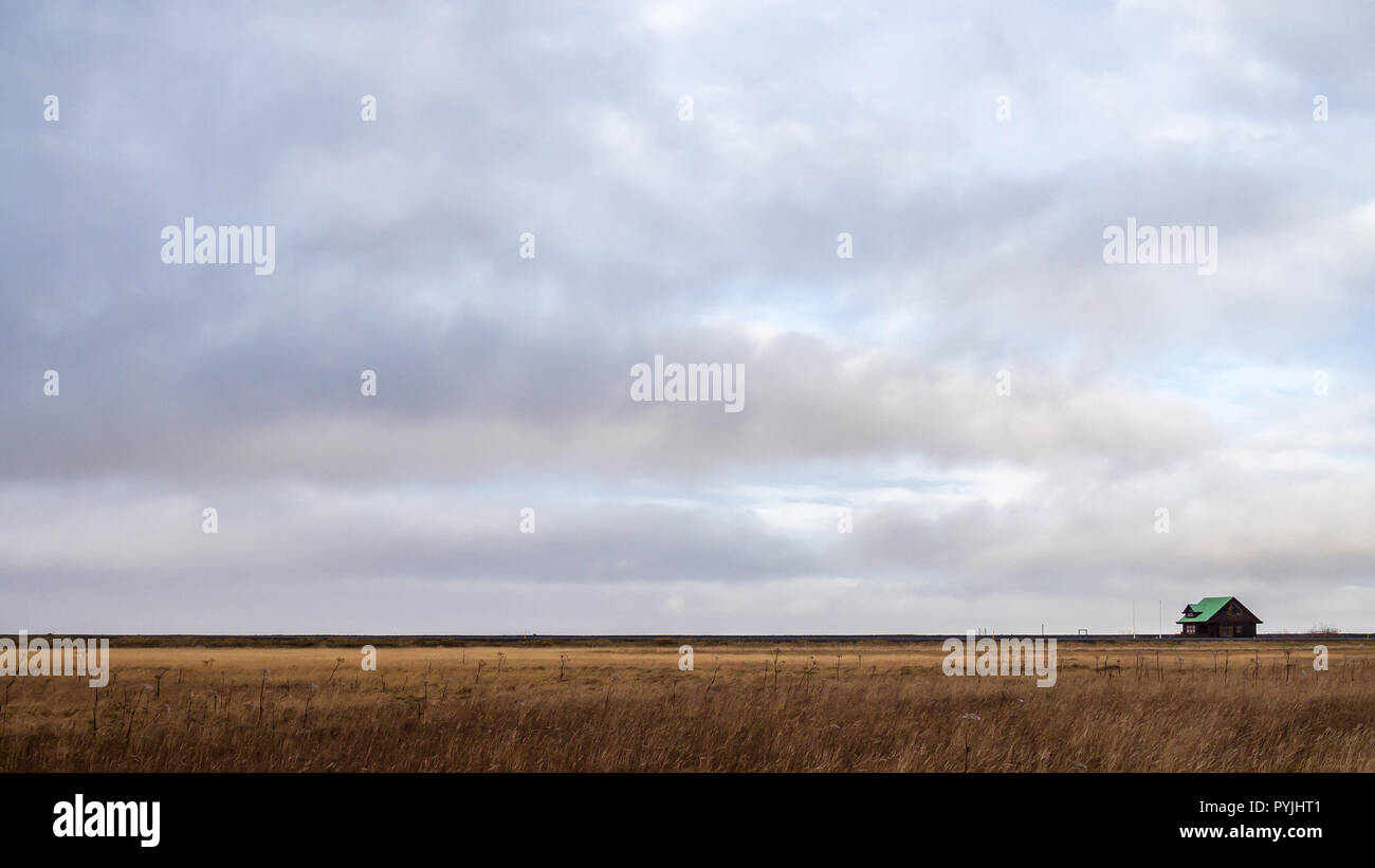 Lonely house on the horizon on clody sky background Stock Photo