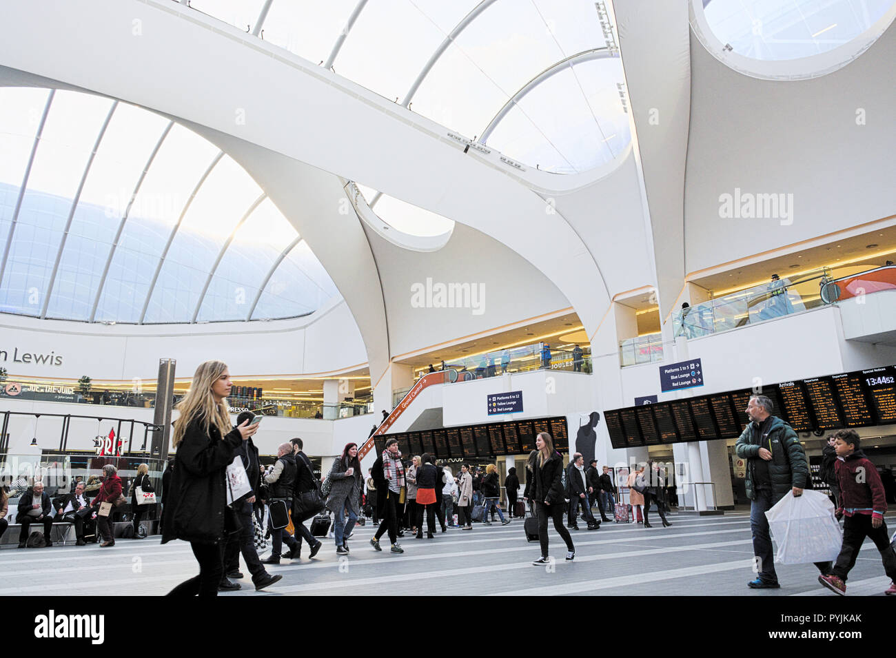 Birmingham New Street Station. Blond girl with bags. People waiting for