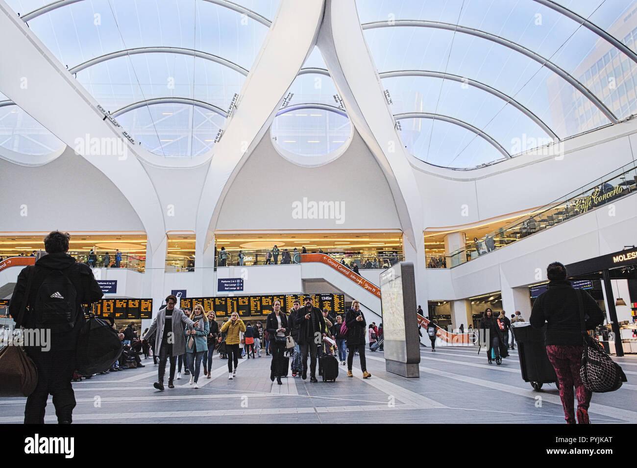 Birmingham New Street Station. Woman with travel suitcase. Men with