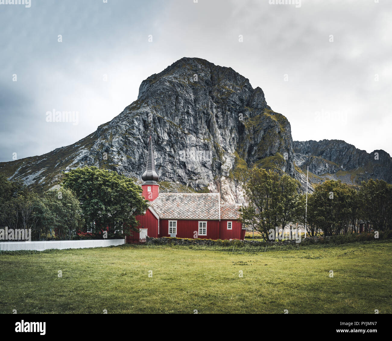 Flakstad Church with mountains in the background, exquisite XVIII century baroque masterpiece in the Arctic, Flakstadoy, Lofoten Islands, North of the Stock Photo