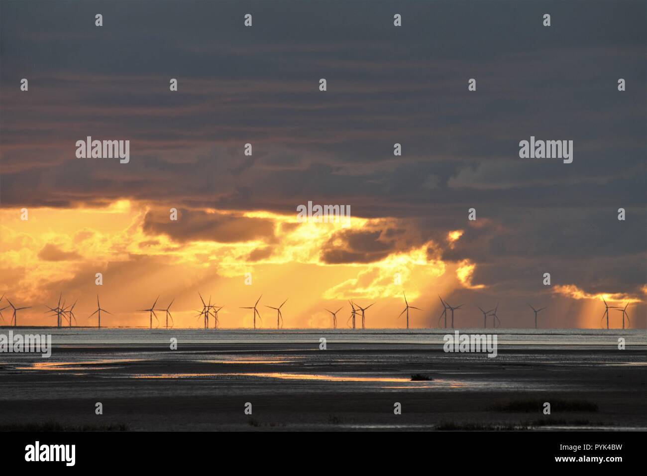 Cumbria UK. 28th October 2018. UK Weather. After a cold clear autumn day the sun sets beyond the Walney Windfarm on the Cumbrian Coast. Credit C.Hall / Alamy Live News Stock Photo