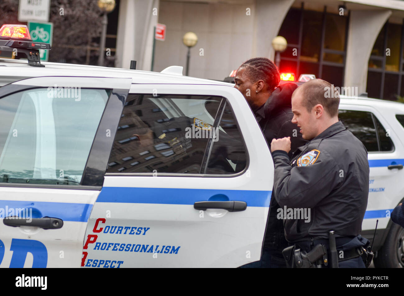 NYPD officers are seen arresting a bike messenger for unknown reasons at the 7th Avenue and 59th street  (Central Park) in New York City. Stock Photo