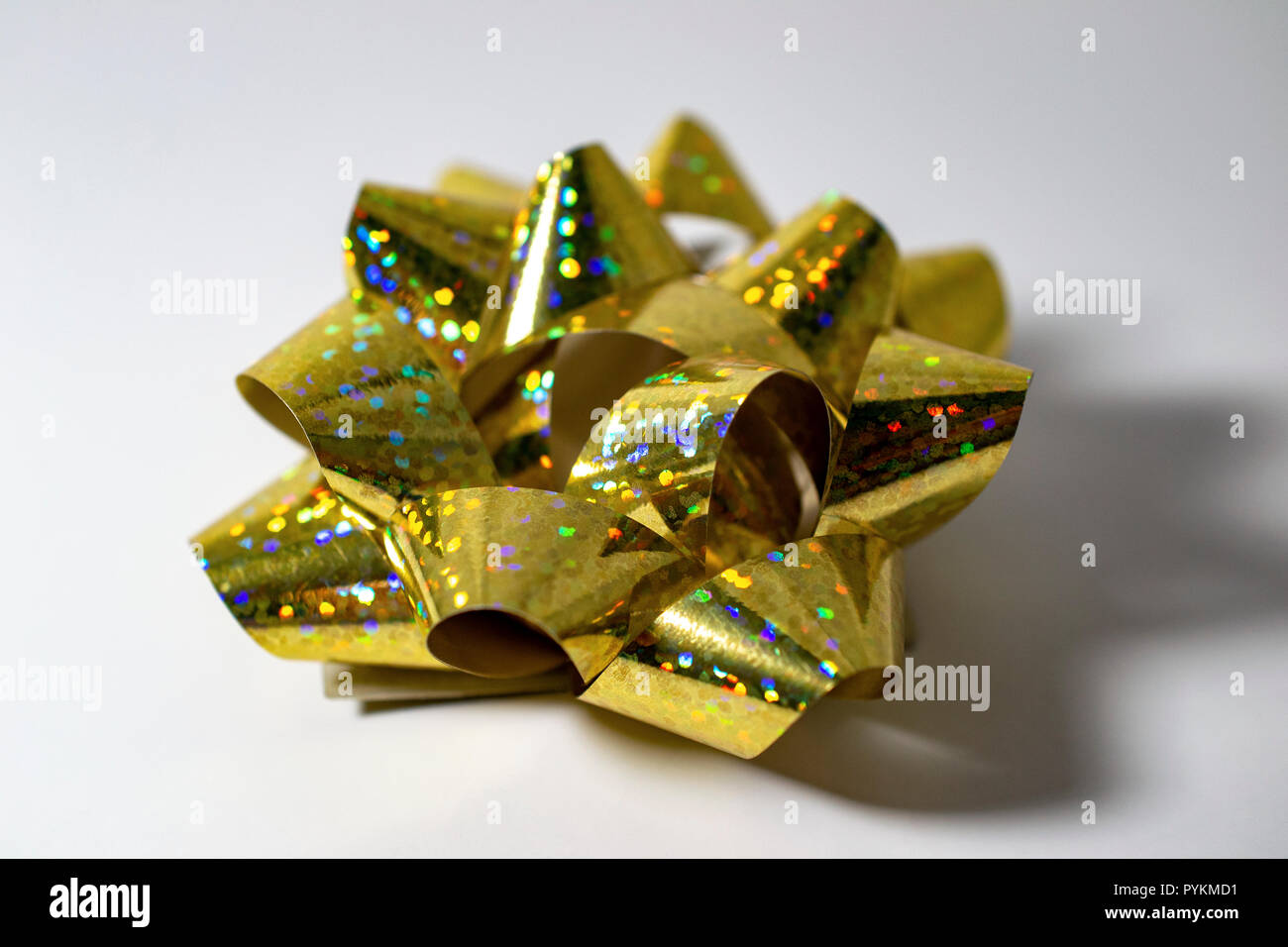 1 Single Sparkly Gold Golden Satin Bow Ribbon Christmas Holiday Light Background. Room for Copy. Stock Photo