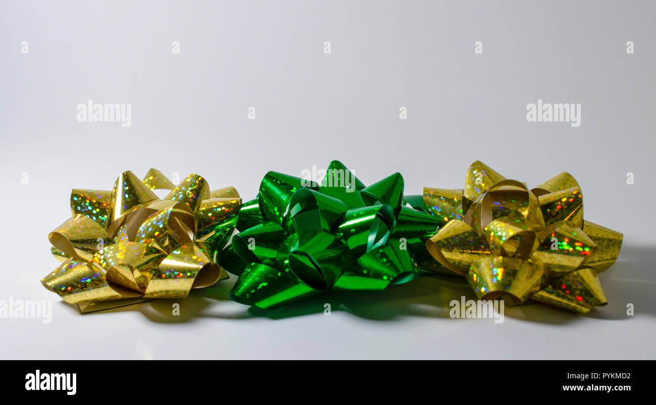 Three  Christmas Holiday Satin Ribbon Bows. 2 sparkly gold, 1 Christmas Green.  Room for Copy. Stock Photo