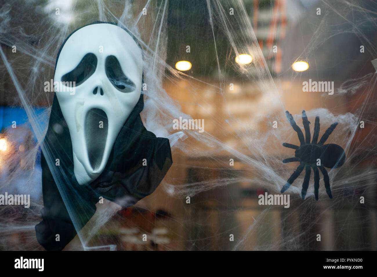 27.10.2018, Singapore, Republic of Singapore, Asia - A Scream mask and a fake spider are used for Halloween decoration in a shop window. Stock Photo