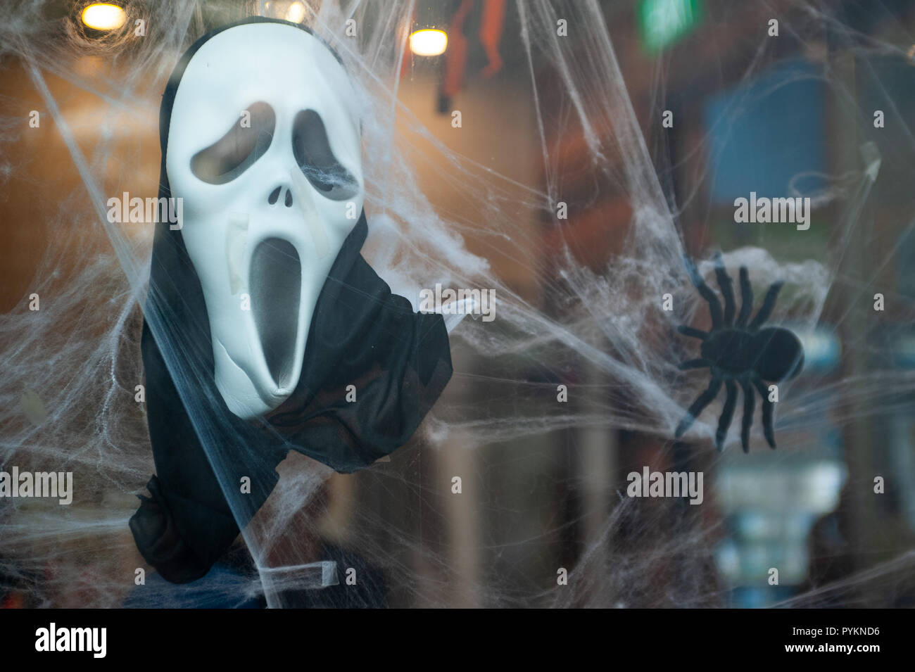 27.10.2018, Singapore, Republic of Singapore, Asia - A Scream mask and a fake spider are used for Halloween decoration in a shop window. Stock Photo