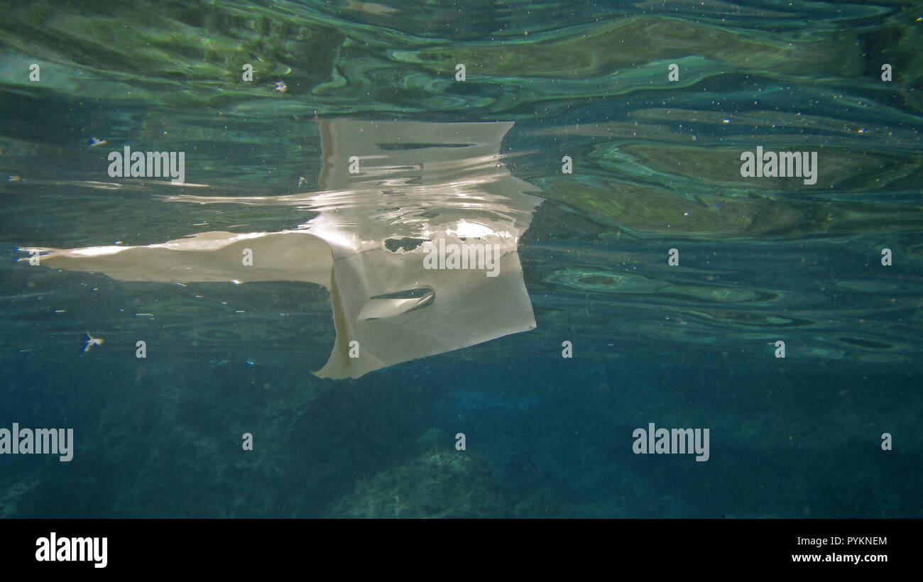 Plastic bag floats on water surface, pollution concept with copy space Stock Photo