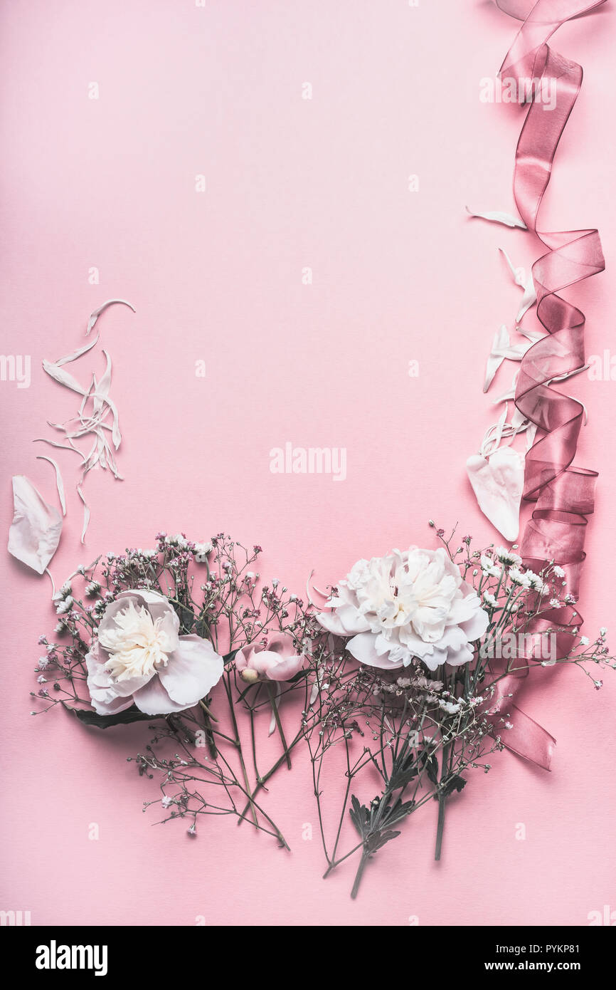 Floral frame with peonies and ribbon on pastel pink background, top ...