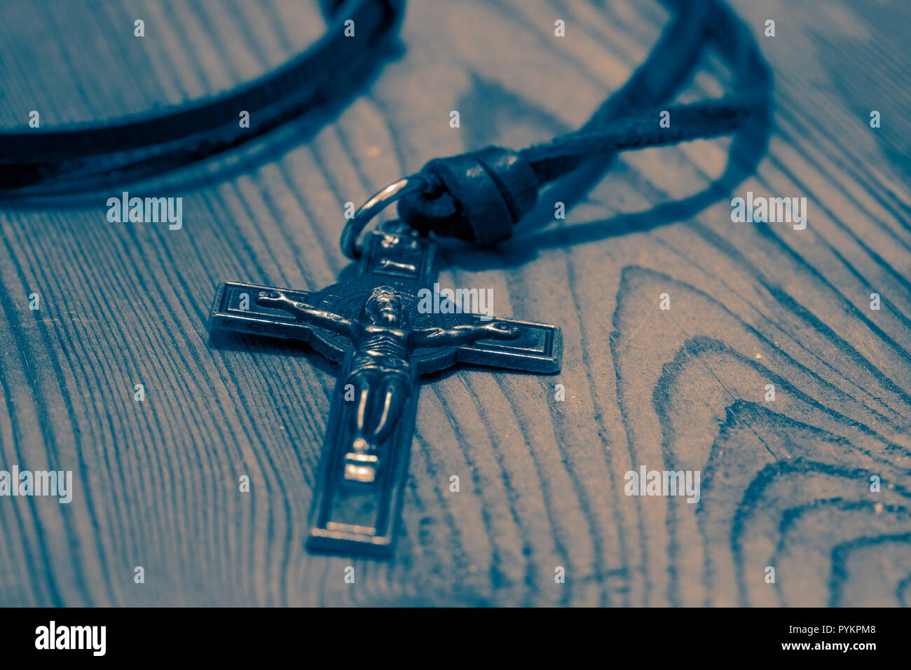 Crucifix cross necklace on a wood background with toning Stock Photo