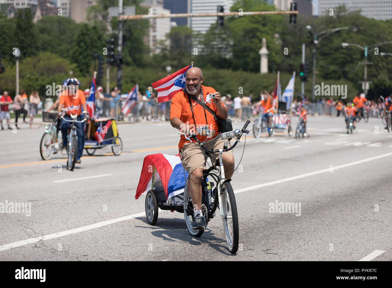 Chicago, Illinois, USA - June 16, 2018: The Puerto Rican Day Parade, Member of the Classic Cruisers Bicycle Club riding a bicycle with the puerto rica Stock Photo