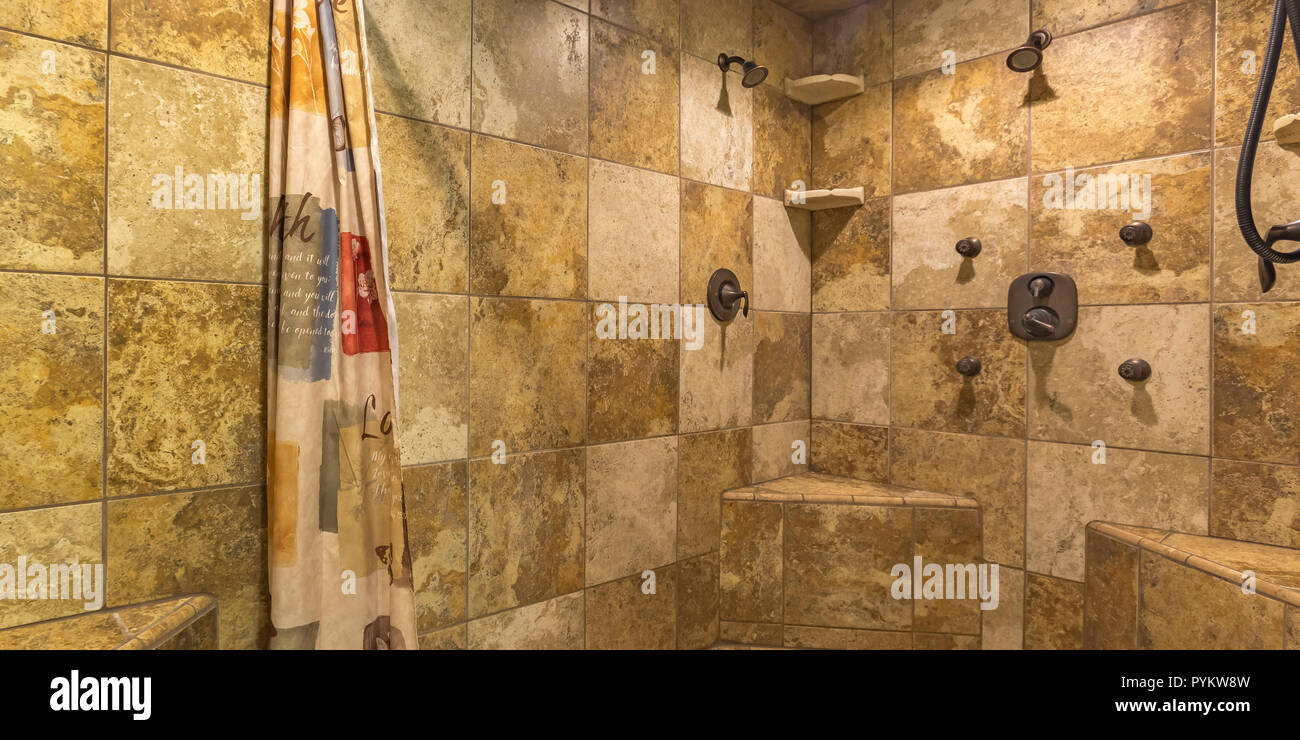 Walk in shower with brown tile wall and curtain Stock Photo Alamy