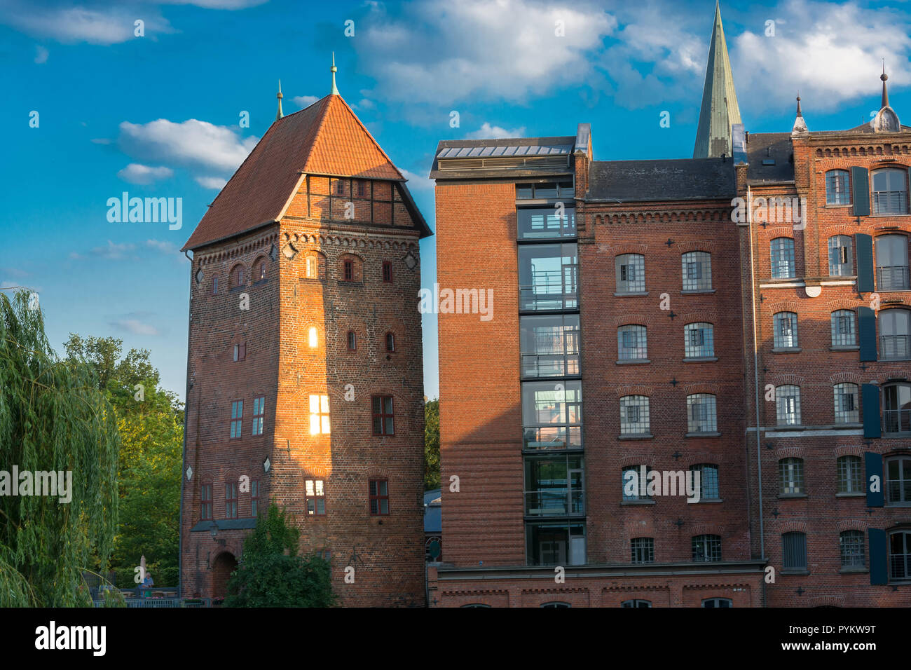 View of a hotel in the German city of Lüneburg. Beautiful cityscape with reflections of houses on water and sky with clouds. Stock Photo