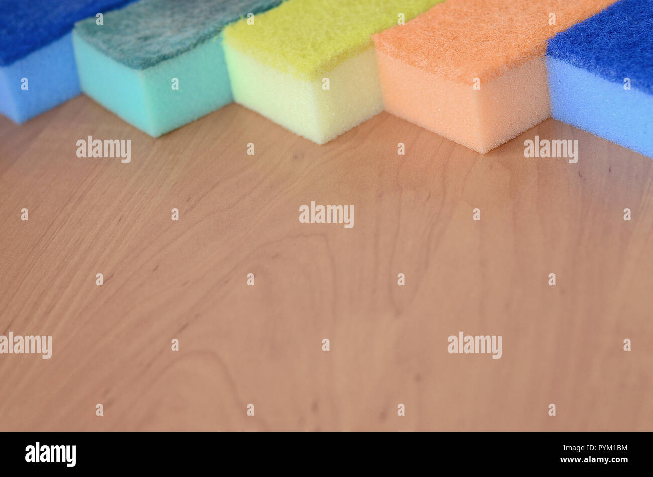 https://c8.alamy.com/comp/PYM1BM/a-few-kitchen-sponges-lie-on-a-wooden-kitchen-countertop-colorful-objects-for-washing-dishes-and-cleaning-in-the-house-are-ready-for-use-PYM1BM.jpg