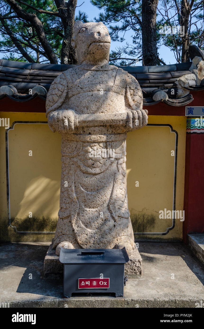 Stone sculpture representing the ox deity from the Chinses Zodiac, seen here at Haedong Yonggung Temple, Busan, South Korea. Stock Photo