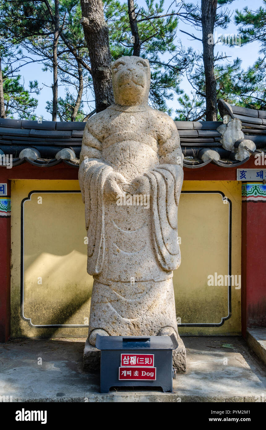 Stone sculpture representing the dog deity from the Chinses Zodiac, seen here at Haedong Yonggung Temple, Busan, South Korea. Stock Photo