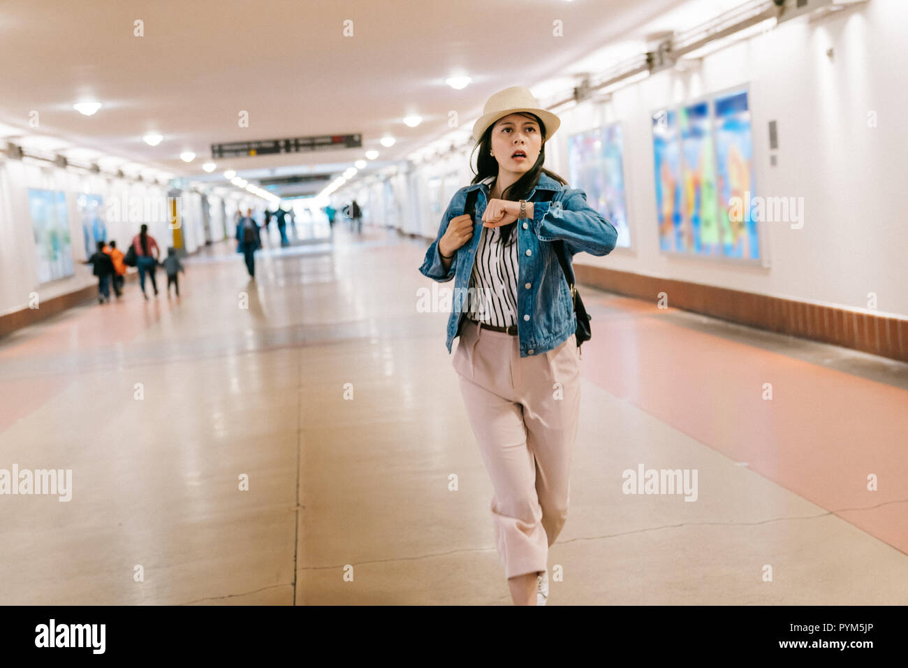beautiful lady trying to catch the train and looking at her watch. Young woman hurry up and running in the corridor in Union station in LA. attractive Stock Photo