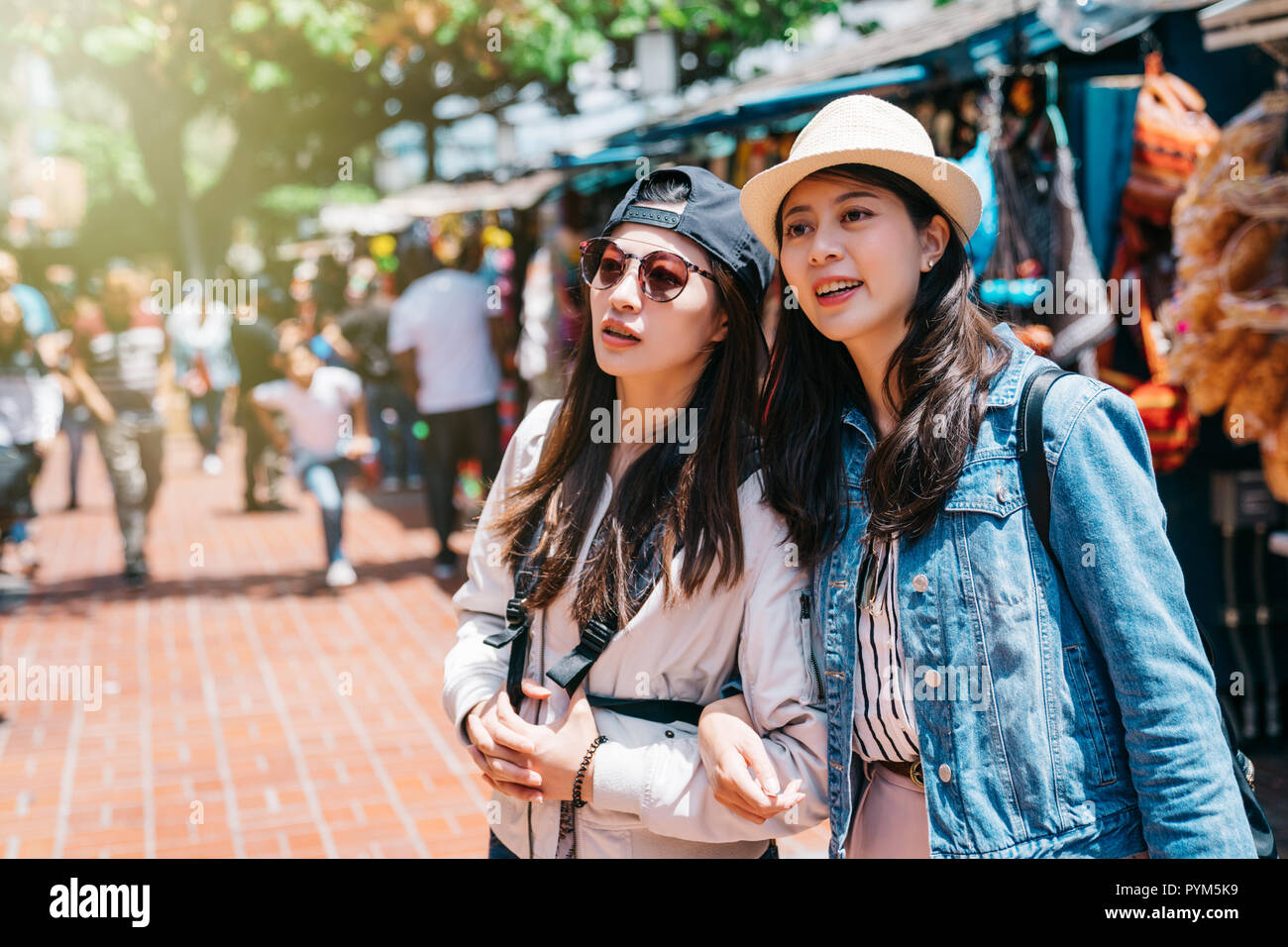 pretty women standing and discussing the fresh things to them in the Mexican market in Los Angeles. Friendship concept with young sisters having fun i Stock Photo