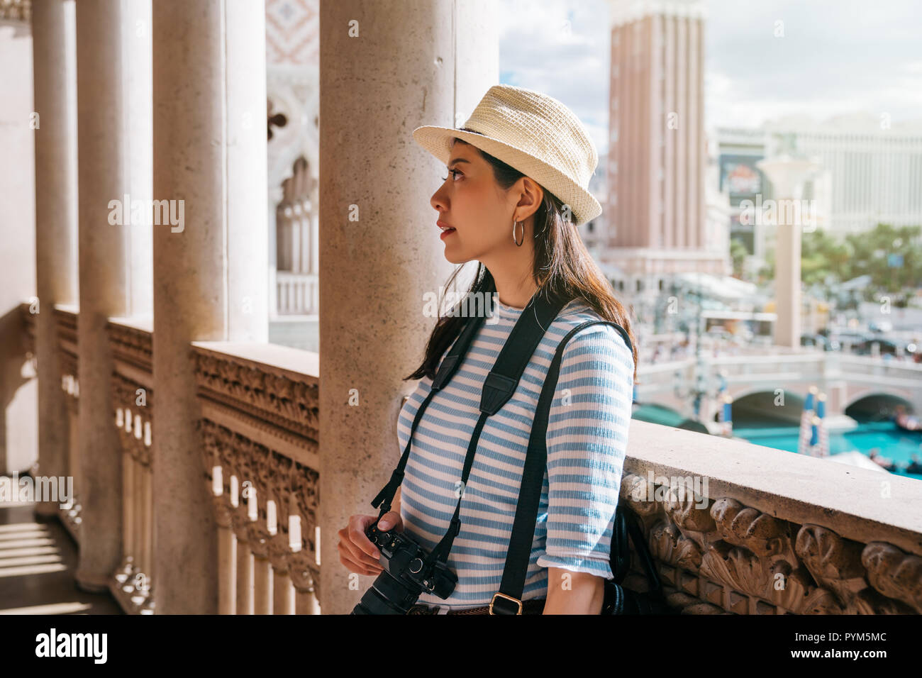 female tourist standing in the corridor in classic design building. young traveler relaxing seeing the amazing beautiful ceiling.   lady photographer  Stock Photo