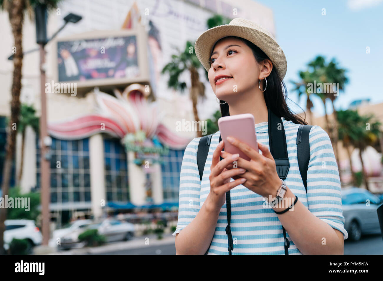 traveler walking on the street in Las Vegas and finding the way to casino. young lady hobby is a gambler using online map app cellphone to get the rig Stock Photo