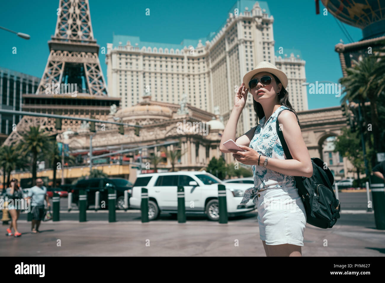 Beautiful lady watching the famous hotel in Las Vegas, standing in the busy  city. Famous tourist Stock Photo by travnikovstudio