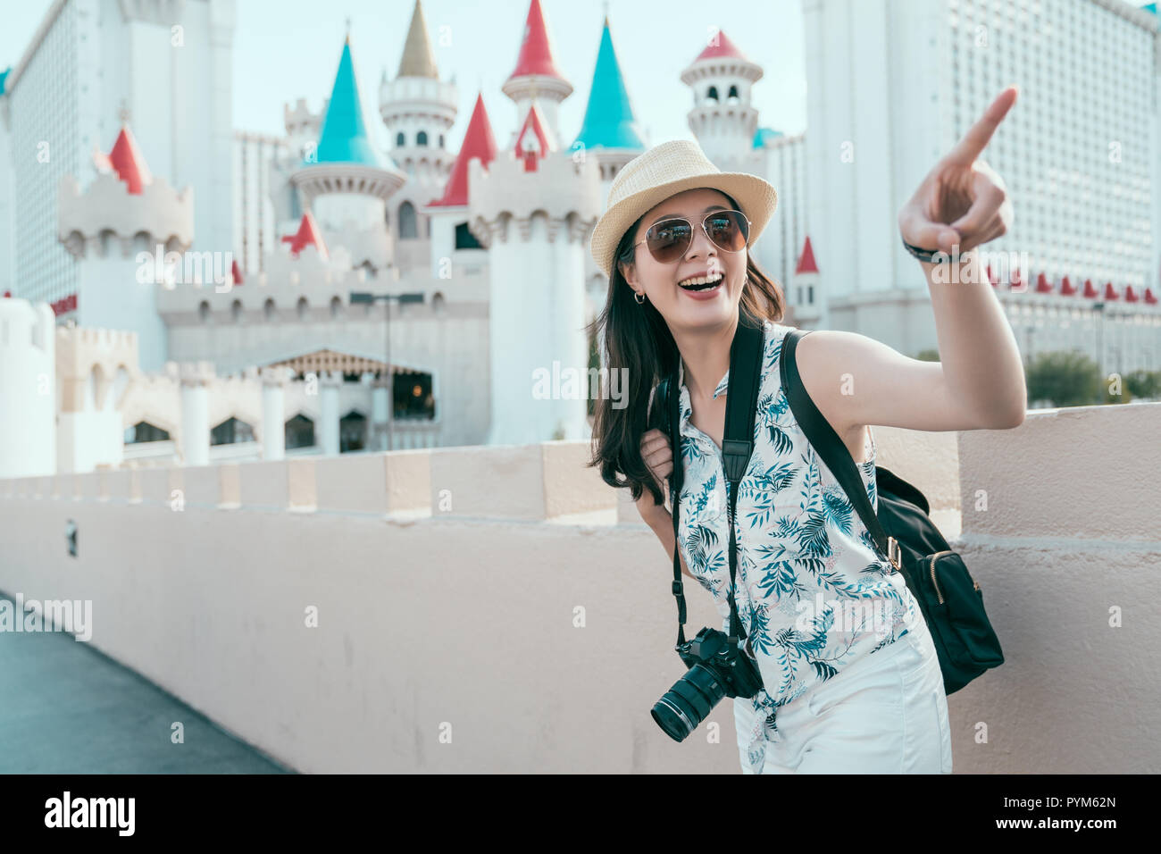 young travel photographer pointing at the beauty of the sky on sunny day. background is a famous castle in las vegas. travel in USA  lifestyle. Stock Photo