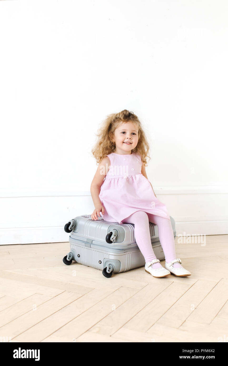Adorable girl on suitcase Stock Photo