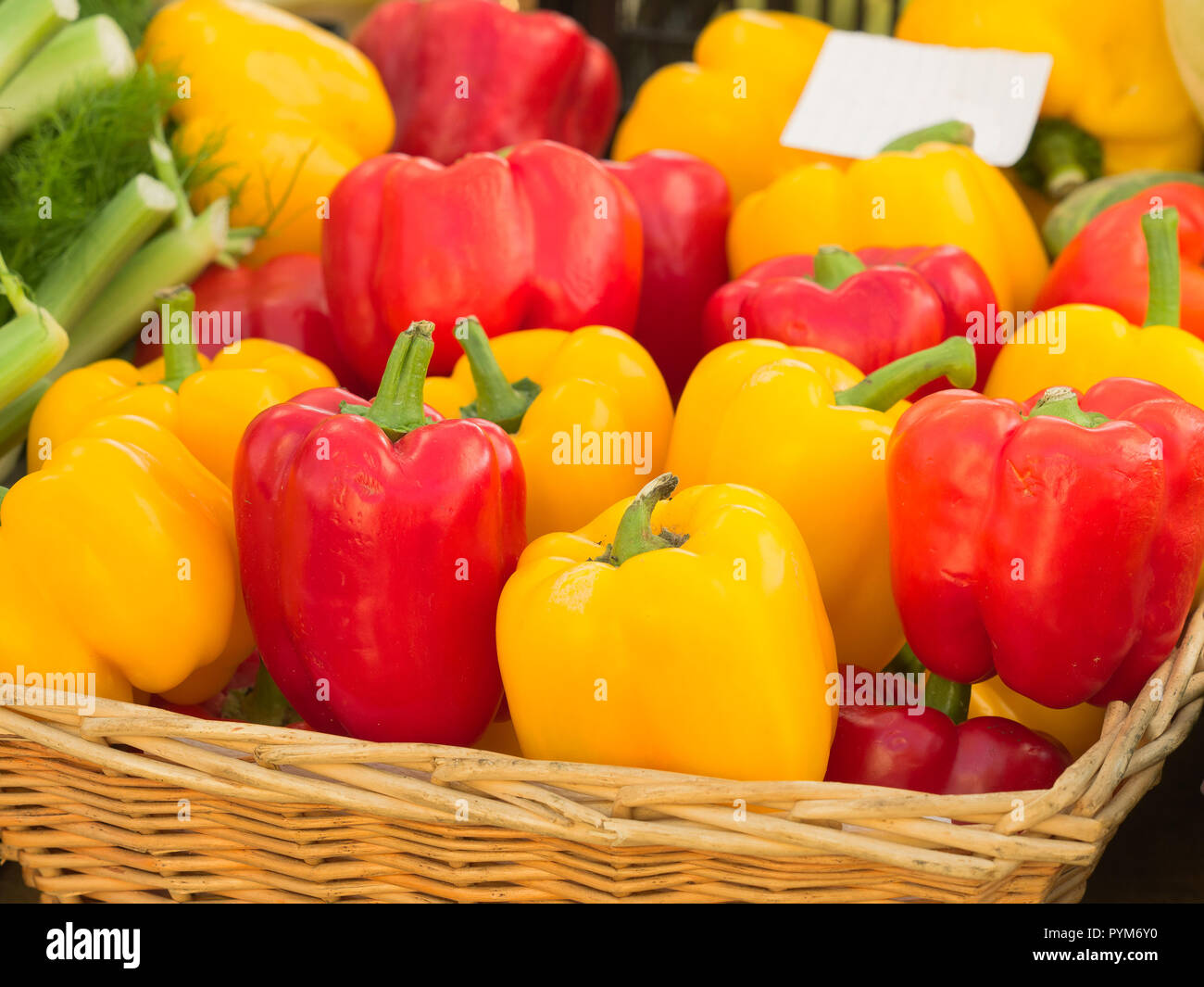 organic red and yellow pepper in a wicker basket at a country market ...