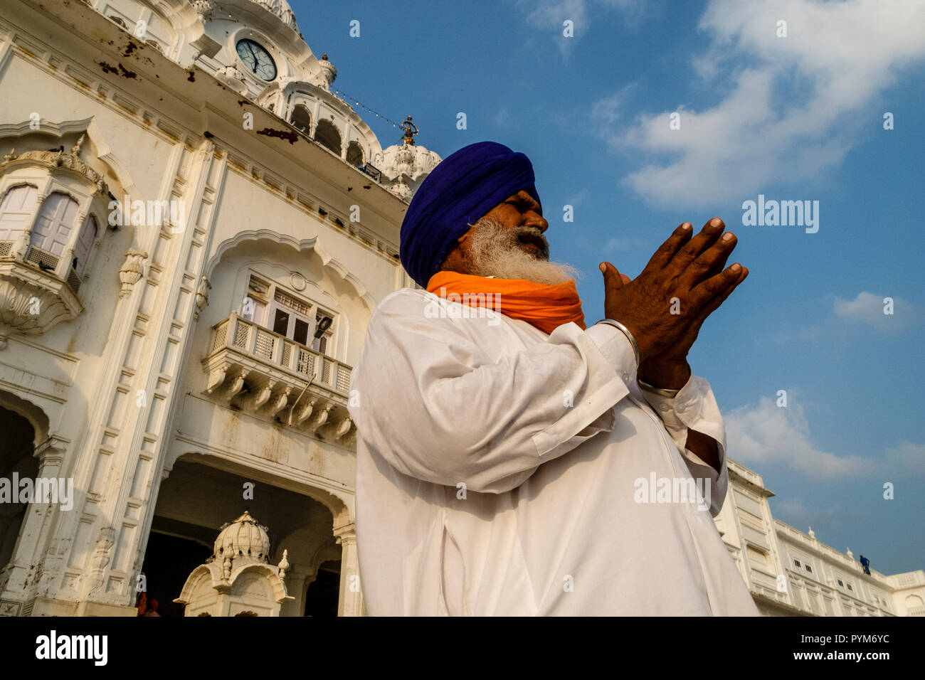 Sikh devotee praying at the entrance into the Golden Temple Complex Stock Photo