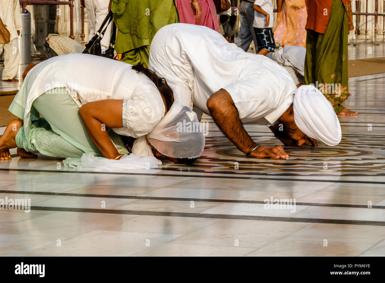 Sikh devotees praying at the entrance into the Golden Temple Complex Stock Photo