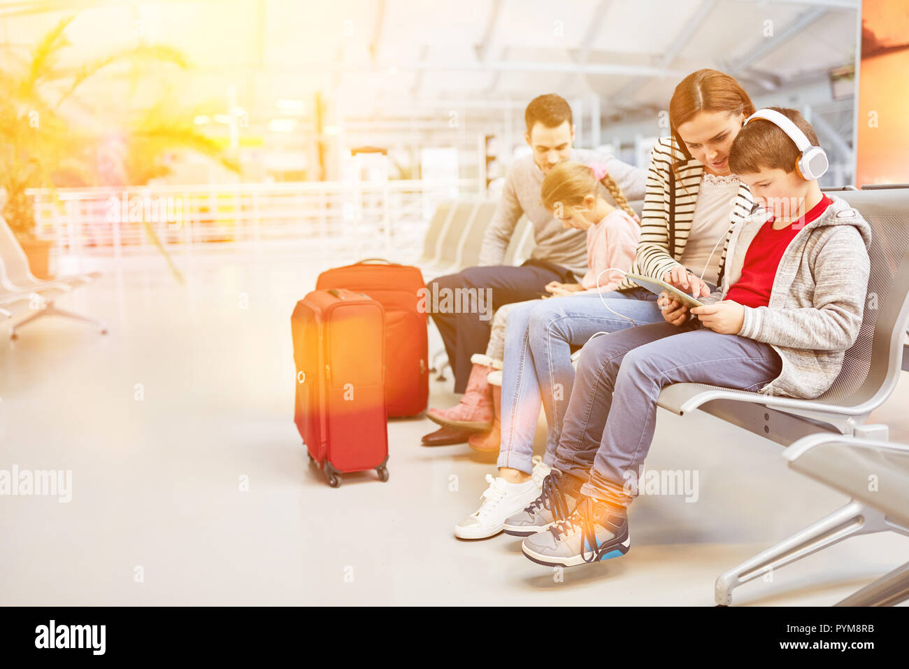 Family with children on vacation while waiting at the airport terminal Stock Photo