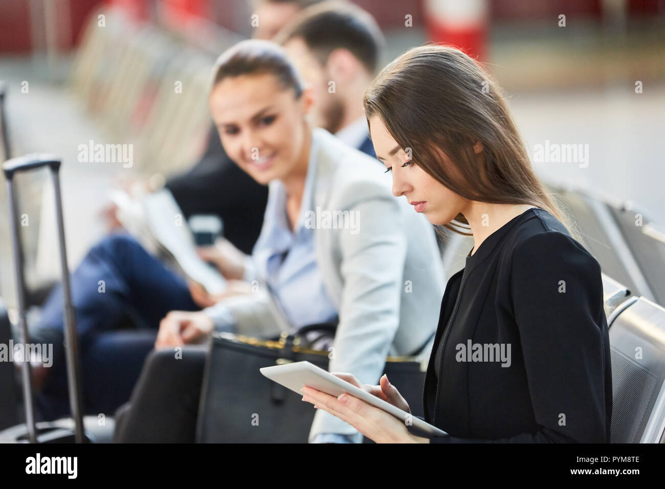 Young business woman with tablet computer on business trip in airport terminal Stock Photo