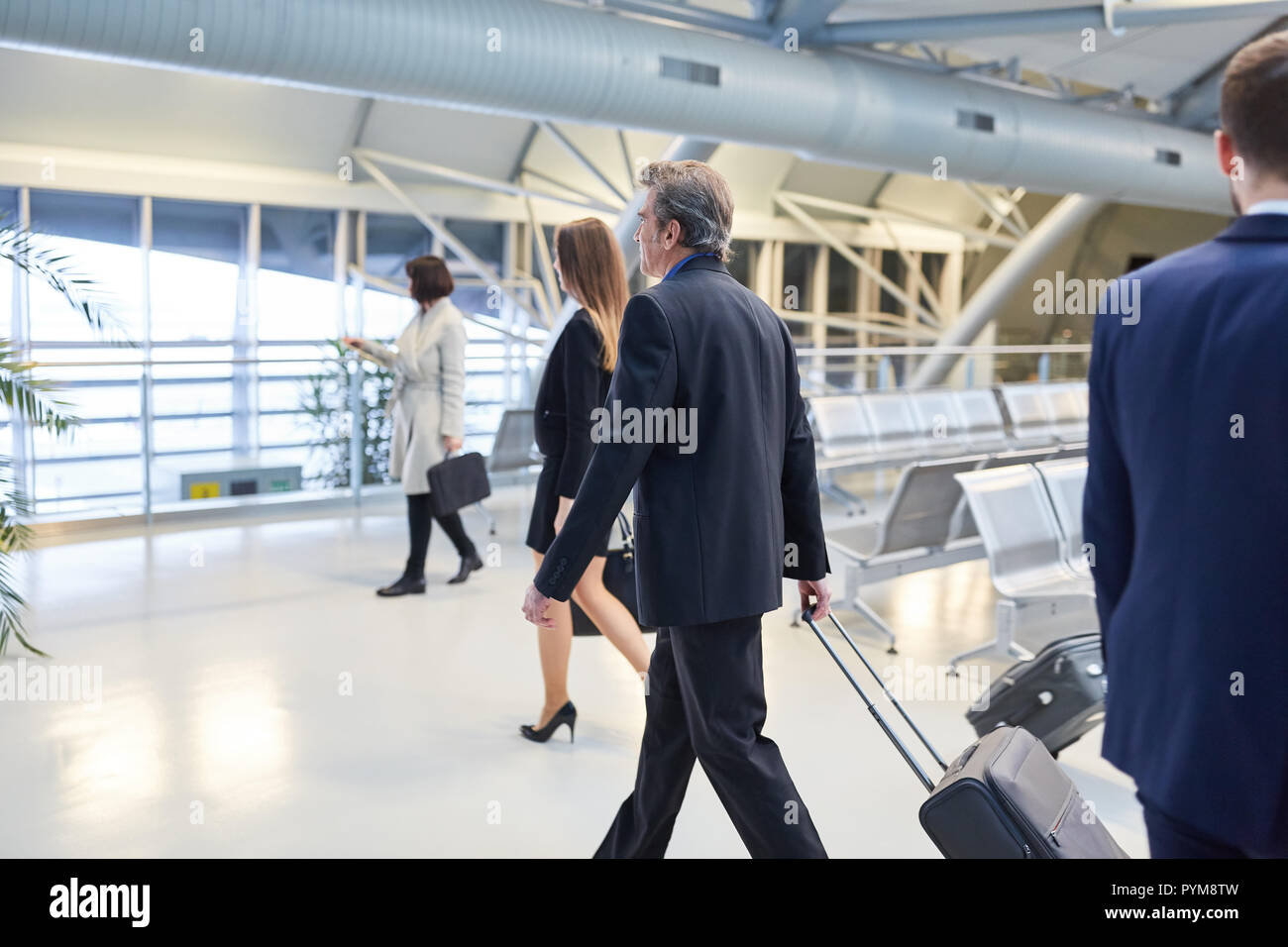 Business people as passengers are in a hurry on their journey in the airport terminal Stock Photo