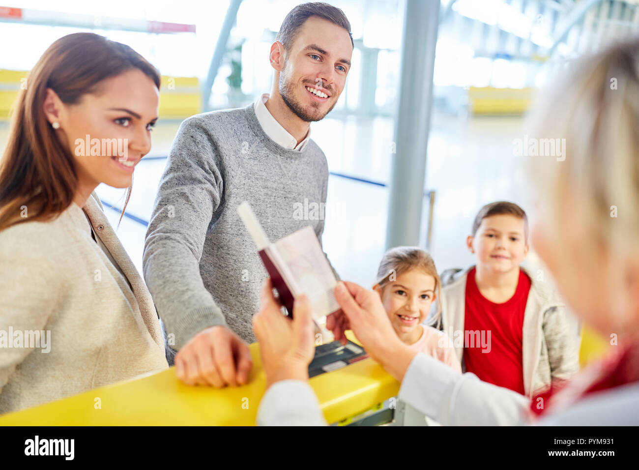 Family and children at the check-in counter in the airport terminal at the passport control Stock Photo