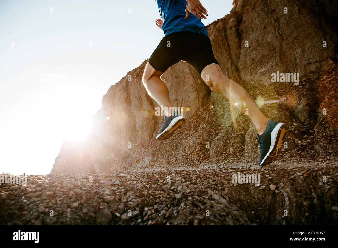 healthy lifestyle middle aged man runner running on mountain trail in sunset Stock Photo