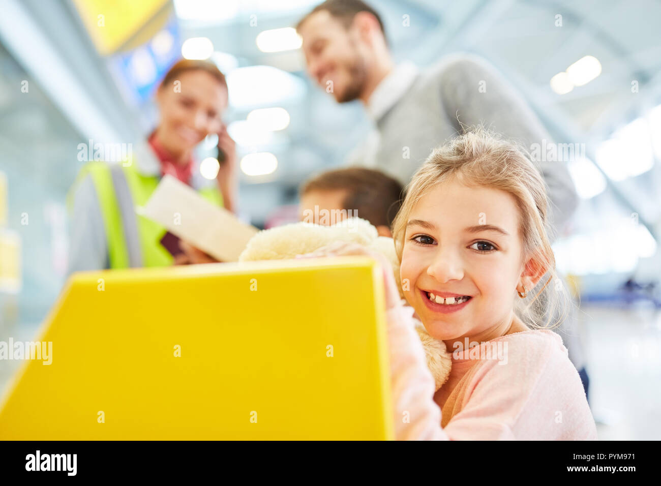 Little girl and family at the check-in desk at the airport terminal are checked Stock Photo