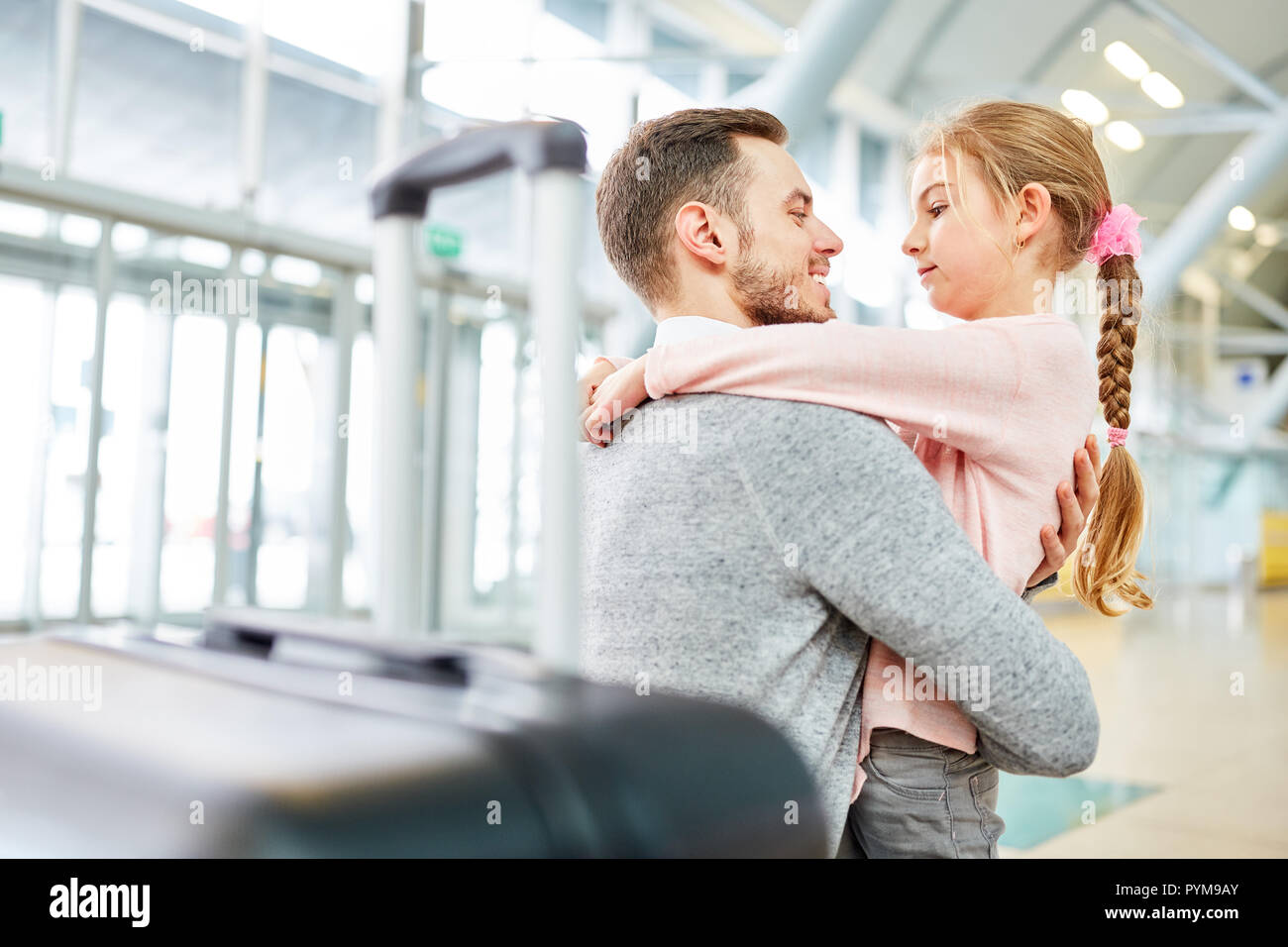 Daughter picks up her father at the airport terminal and hugs him in ...