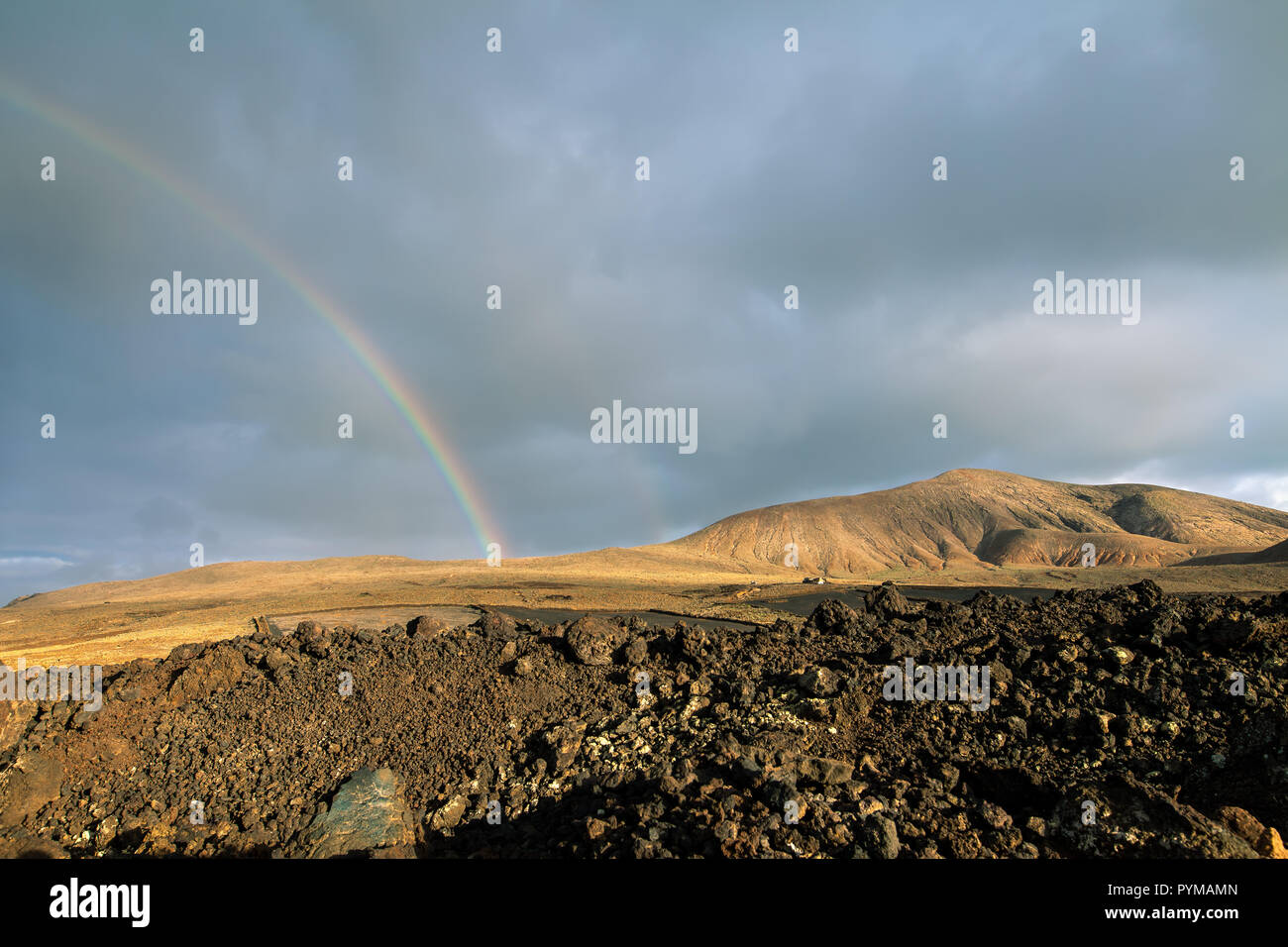 Rainbow in mountains valley. Beautiful nature landscape Stock Photo