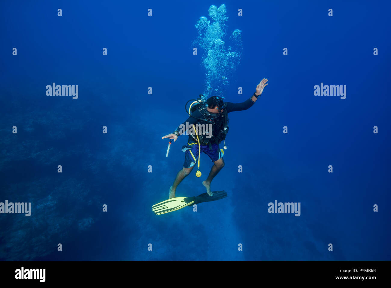 Underwater surfing. Scuba diver embarked on fins and rides them in